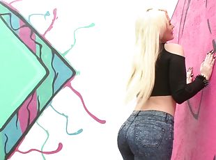 Curvy blonde with long hair in jeans coping up with huge python har...
