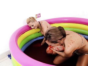 Bikini girls play in a little pool filled with sticky red goo