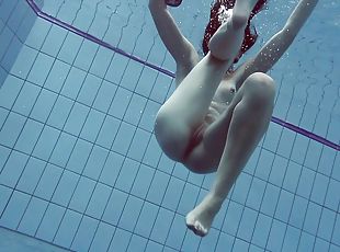 Slender raven-haired stunner undresses while diving in the pool