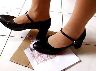 Girl stomping on paper in high heels, crushing trampling picture in...