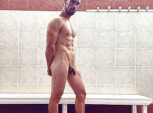 Fit stud naked in public locker room flexing muscles after gym trai...