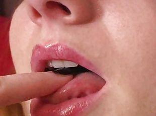 Closeup on her mouth as she licks fingers