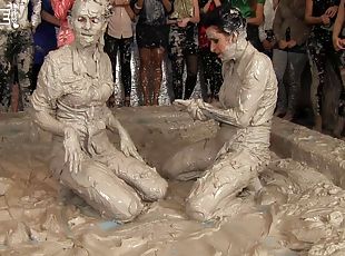 Leather-clad brunette with a sexy body having a catfight in a mudbath