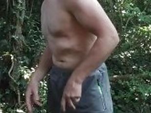 Shirtless muscle stud gets naked, flexes his muscles, masturbates and cums in the woods