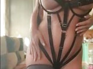 Hot milf in a BDSM costume sweetly fingering her pussy and caressin...