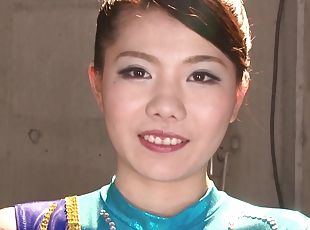 Japanese gymnast in a shiny leotard bends her body and blows him