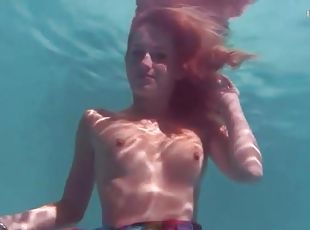 Redhead in a pretty dress takes us underwater