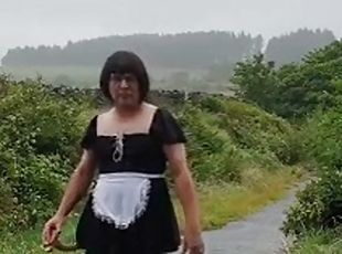 Transvestite maid in a public lane in the rain