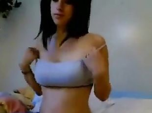Sexy brunette who takes off her clothes on bed and plays with her big boobs