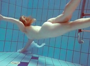 Redhead goes for a nude swim in the pool