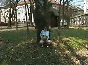 Squats by a tree and pees her pants