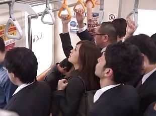 A very daring Japanese babe sucks a guy's cock on a crowded subway